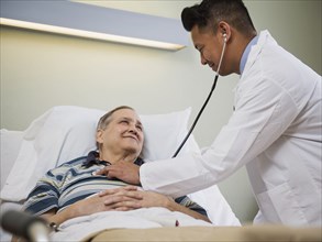 Doctor listening to chest of patient with stethoscope