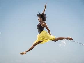 Water spraying on black woman ballet dancing