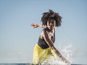 Black woman splashing in water