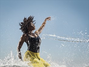 Water spraying on black woman dancing