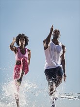 Water splashing on legs of running Black couple
