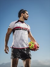 Hispanic man holding soccer ball
