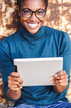 Smiling African American woman holding digital tablet