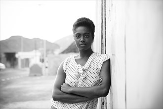 Serious African American woman leaning on wall