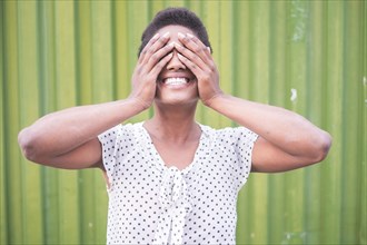 Smiling African American woman covering eyes