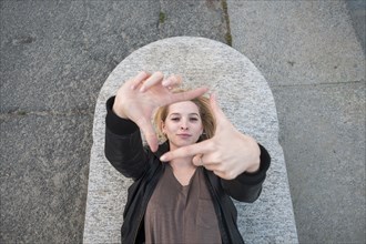 Caucasian woman laying on concrete gesturing square