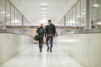 Rear view of Caucasian couple walking in corridor
