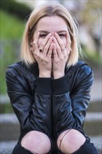 Laughing Caucasian woman covering face with hands
