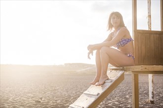 Caucasian woman sitting on cabana at beach