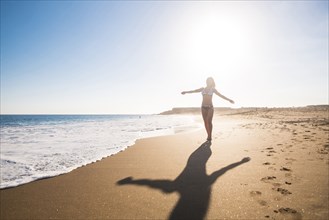 Carefree Caucasian woman walking on beach