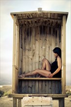 Caucasian woman sitting in cabana on beach