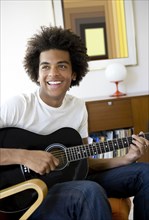 Mixed race man playing guitar