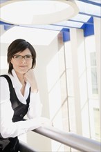 Hispanic businesswoman standing in office lobby