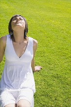 Hispanic woman relaxing on grass