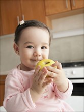 Hispanic baby girl eating apple