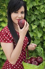 Hispanic woman holding basket of apples
