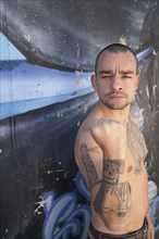 Bare chested Hispanic man with tattoos
