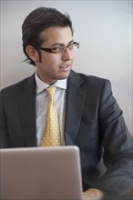 Hispanic businessman typing on laptop