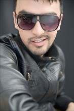 Hispanic man in sunglasses and leather coat