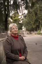 Senior Hispanic woman sitting in park