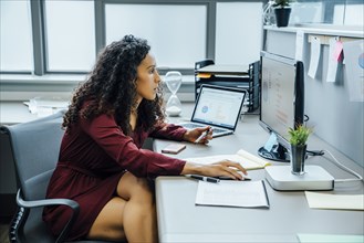 Mixed race businesswoman using computer in office