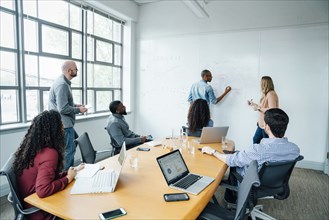 Business people using whiteboard in meeting