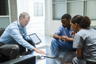 Doctor and nurses discussing digital tablet