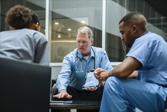 Doctor and nurses discussing digital tablet