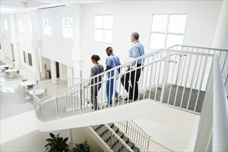 Doctor and nurses descending staircase