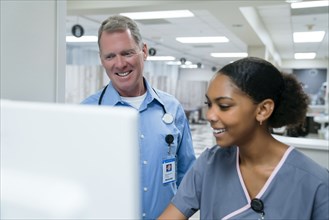 Smiling doctor and nurse using computer