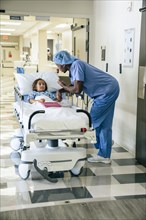 Nurse talking to girl in hospital gurney