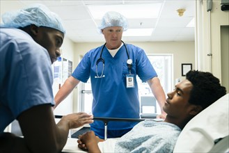 Nurses talking to boy in hospital bed