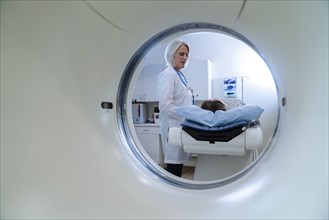 Caucasian doctor talking to patient near scanner