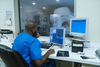 Black nurse using computer near scanner