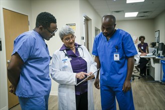 Doctor and nurses discussing digital tablet