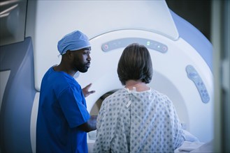 Technician talking to patient at scanner