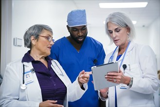 Doctors and nurse discussing digital tablet