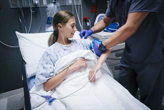 Nurse is measuring blood pressure of girl in hospital