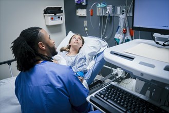 Nurse and patient looking at monitor in hospital