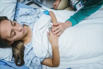 Caucasian doctor comforting patient in hospital bed