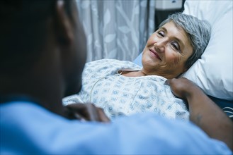 Nurse talking to patient in hospital bed