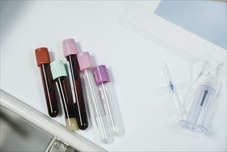 Test tubes with caps on table near syringe