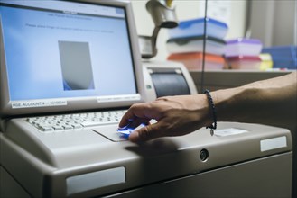 Mixed race nurses using fingerprint scanner