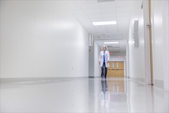 Caucasian doctor walking in hospital