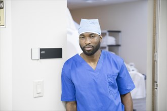 Portrait of confident black nurse near MRI sign