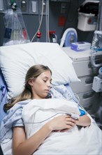 Caucasian girl laying in hospital bed