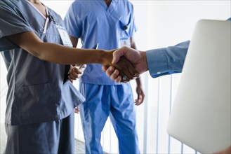 Doctor and nurse shaking hands