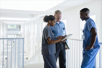 Doctor and nurses using digital tablet near staircase