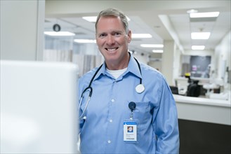 Portrait of smiling doctor using computer in hospital