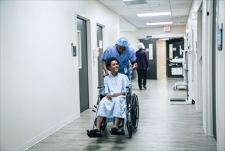 Nurse pushing boy in wheelchair